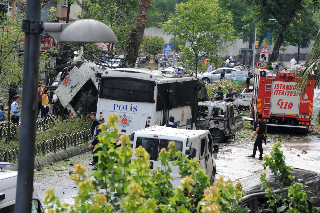 Police officers and rescuers inspect the site of a bomb attack that targeted a police bus in the Vezneciler district of Istanbul on 7 June 2016.