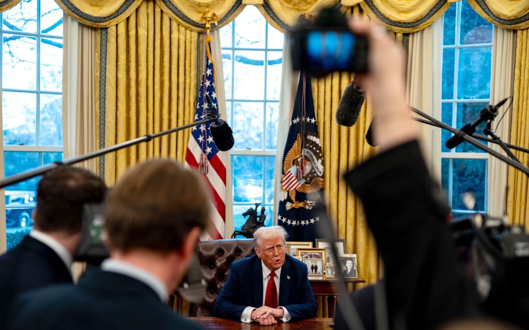 President Donald Trump speaks to members of the press after signing two executive orders in the Oval Office of the White House on January 30 in Washington, DC.