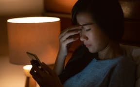 unhappy girl feeling sad reading bad news in smartphone on bed