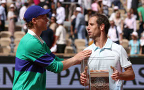 Italy's Jannik Sinner, left, speaks to retiring opponent Richard Gasquet after Sinner's victory in their second round match at the French Open.