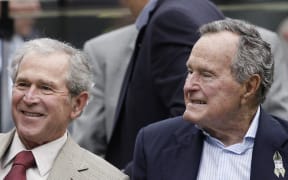 George W. Bush, left, and George H W  Bush at a NFL game in Texas in 2013.