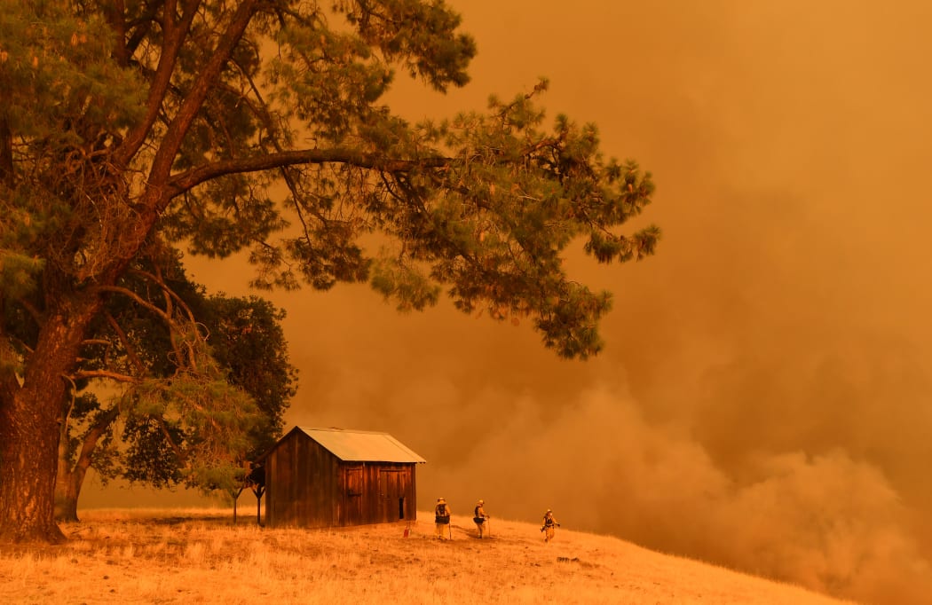 Firefighters watch as flames from the County Fire climb a hillside in Guinda, California, on July 1, 2018.