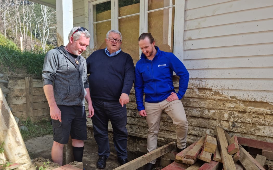 Red-stickered home owner Yoann Martichon, pictured with National Party members Gerry Brownlee and Blair Cameron.