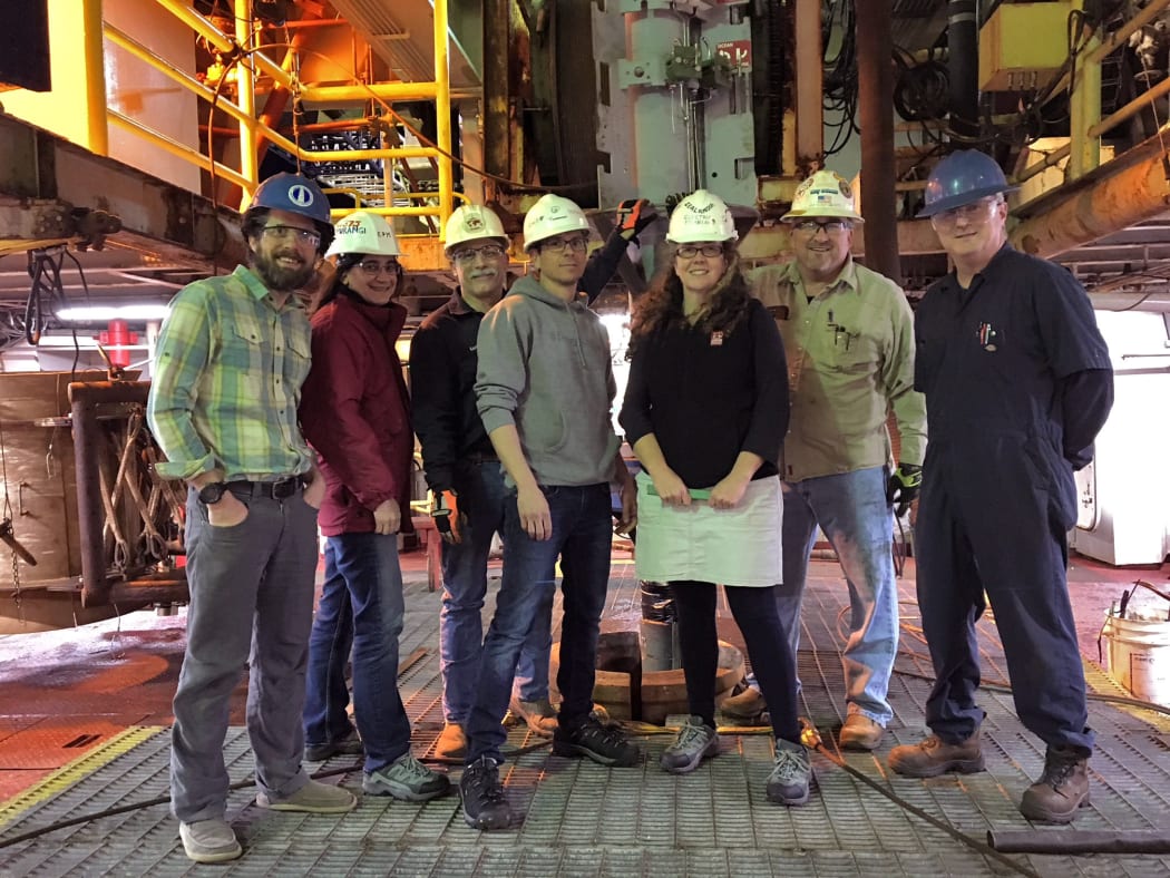 The underwater earthquake observatory team stand next to the wellhead before it is lowered to the seafloor at the Hikurangi subduction zone. Demian Saffer and Laura Wallace are in the centre of the shot.