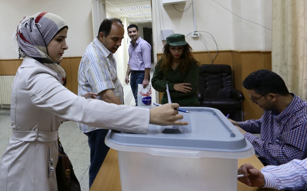 A woman casts her ballot at a polling station in central Damascus.