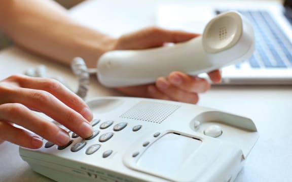 A person dials a number on a home landline phone (file)