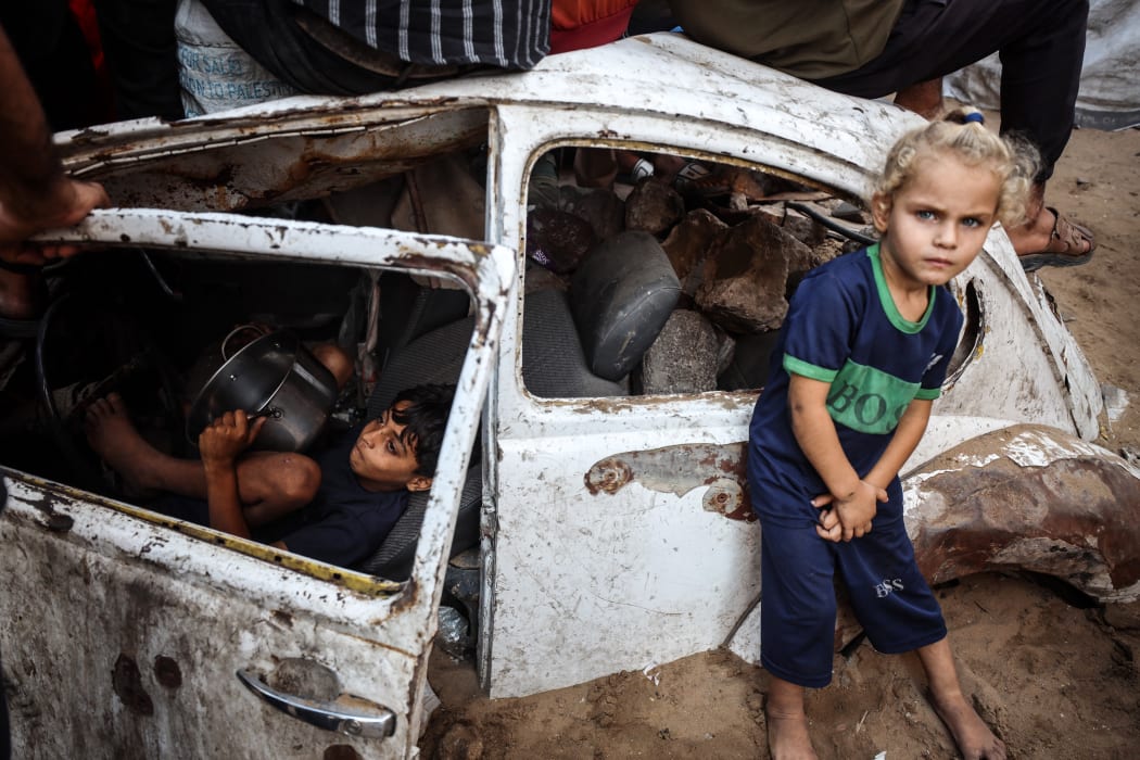 Palestinian children queue for a portion of hot food distributed by a charity kitchen in Gaza City, on July 20, 2025. The World Food Programme says nearly one in three people in Gaza do not eat for days at a stretch and ''thousands'' are ''on the verge of catastrophic hunger''. (Photo by Majdi Fathi/NurPhoto) (Photo by MAJDI FATHI / NurPhoto via AFP)