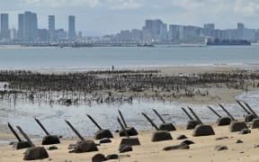 The Xiamen city skyline on the Chinese mainland is seen past anti-landing spikes placed along the coast of Lieyu islet on Taiwan's Kinmen islands, which lie just 3.2km from the mainland China coast, on 10 August 2022.