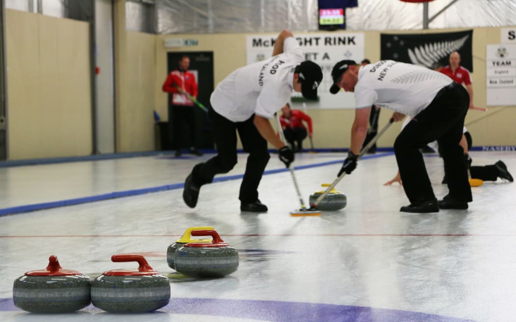 Anton Hood (left) and Warren Dobson sweep ahead of a New Zealand stone