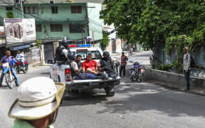 Two men, accused of being involved in the assassination of President Jovenel Moise, are being transported to the Petionville station in a police car in Port au Prince