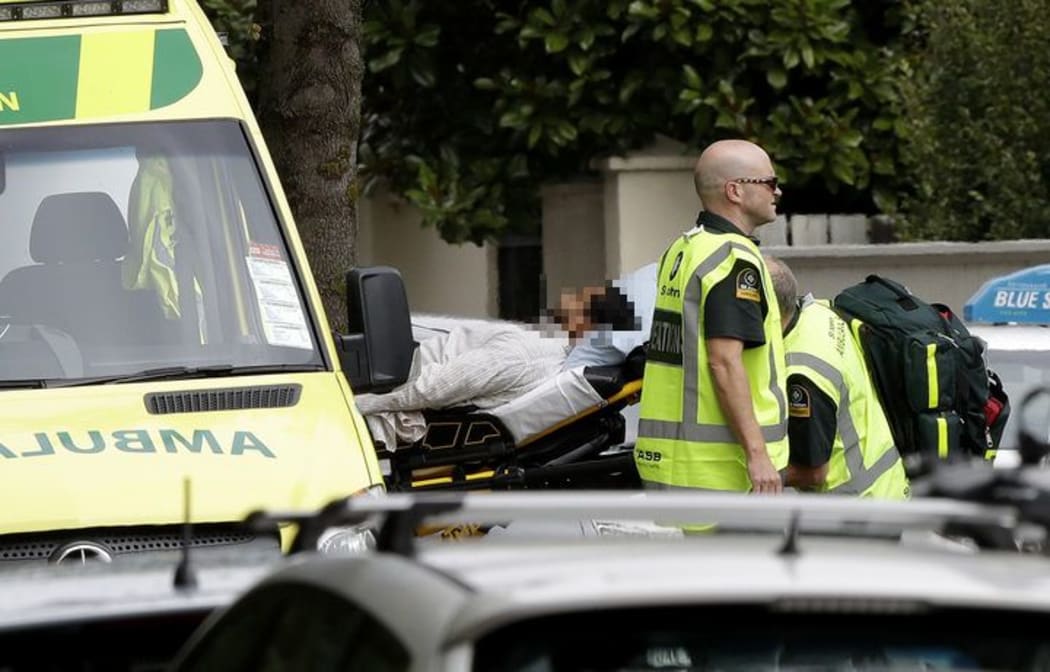 Ambulance staff take a man from outside a mosque in central Christchurch, New Zealand, Friday, March 15, 2019. A witness says many people have been killed in a mass shooting at a mosque in the New Zealand city of Christchurch. (AP Photo/Mark Baker)