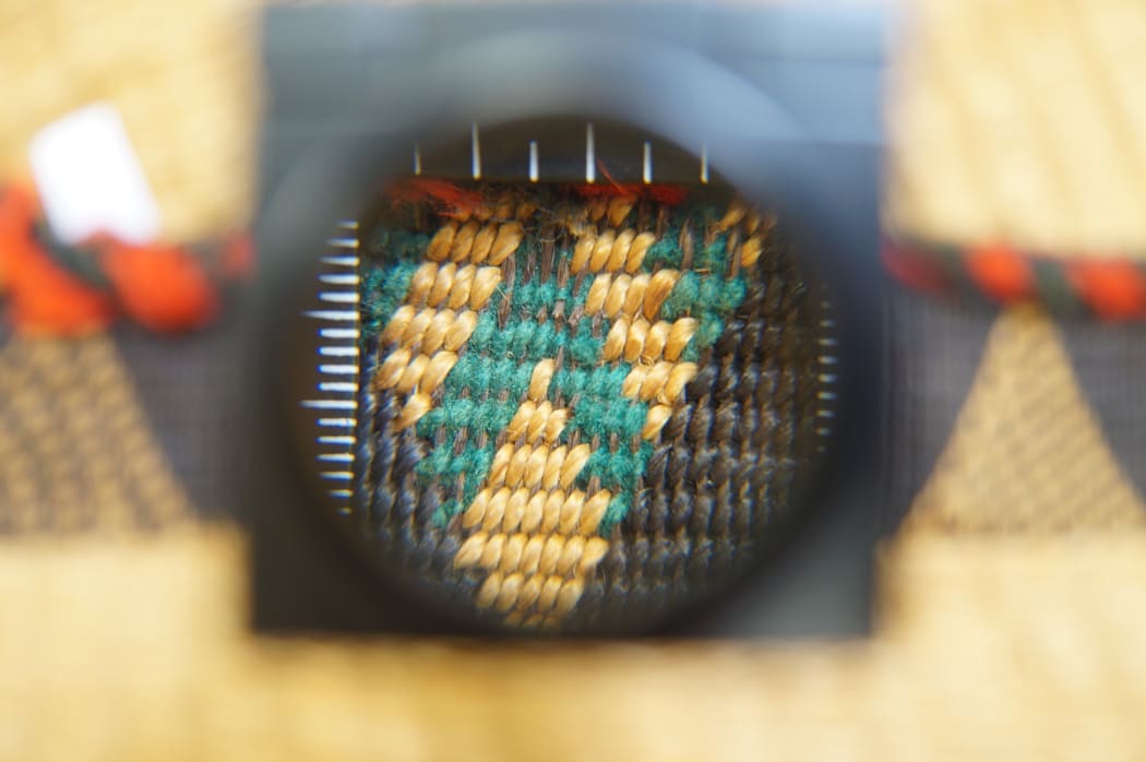 Close up magnified shot of refined weaving on a taniko (finger woven) border.