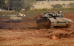 Israeli Merkava tanks take part in a military drill near the border with Lebanon in the upper Galilee region of northern Israel on October 26, 2023, amid the ongoing battles between Israel and the Palestinian group Hamas in the Gaza Strip. (Photo by Jalaa MAREY / AFP)