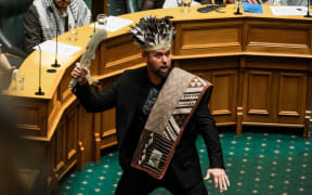 Te Pāti Maori MP Tākuta Ferris, in ceremonial garb, has sworn allegiance to mokopuna under Te Tiriti o Waitangi before also swearing allegiance to the King. The first MP from the party to be called, he was accompanied by a karanga.