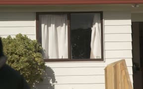 A house front window, smashed by bullets after an early morning shooting in Clendon Park.