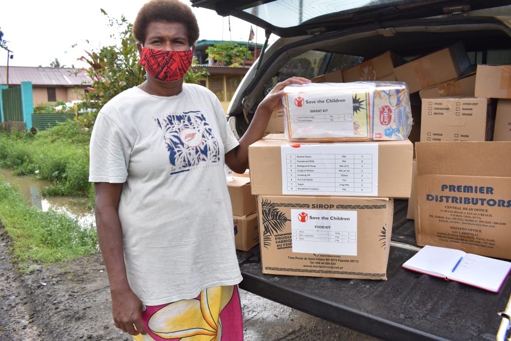 A woman picking up grocery supplies for her family from Save the Children in Fiji.