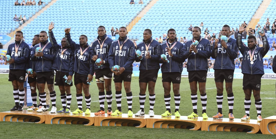 Fiji players stand on the podium after receiving the silver medal after the men's rugby sevens gold medal match against New Zealand at the Robina Stadium during the 2018 Gold Coast Commonwealth Games on the Gold Coast on April 15, 2018. / AFP PHOTO / WILLIAM WEST
