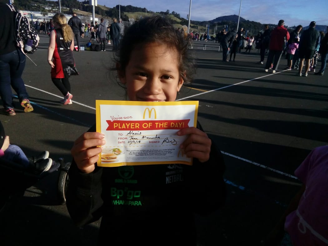 Alexis holding up a player of the day certificate.