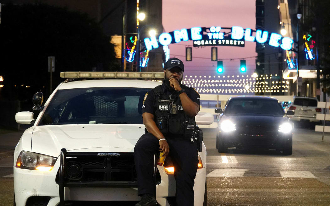A Memphis police officer sits on the hood of a patrol car on historic Beale Street after President Donald Trump said the US would deploy the National Guard to Memphis, in Memphis, Tennessee on September 12.
Mandatory Credit:	Karen Pulfer Focht/Reuters via CNN Newsource