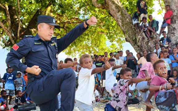 Local kids learning Chinese Kungfu from a member of the China Police Liaison Team.