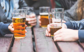 A group of friends drink beer at a bar.