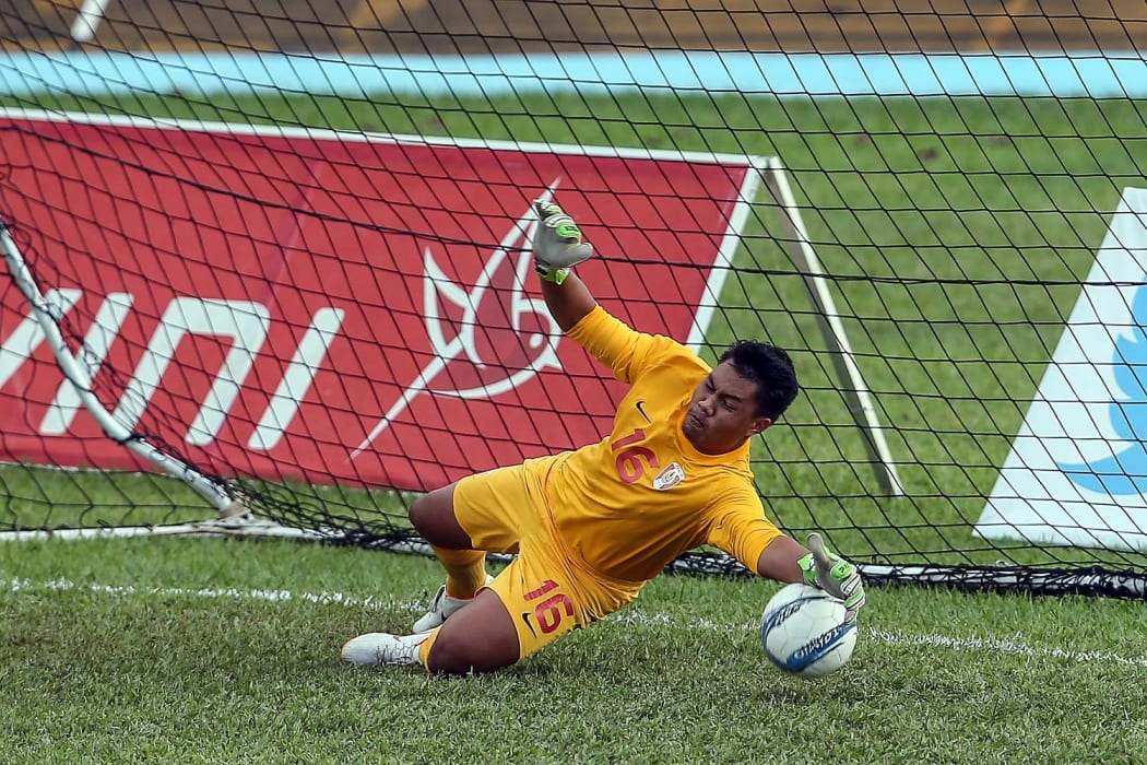 Tahiti's Tevaearai Tamatai saves a penalty to deny Tonga.