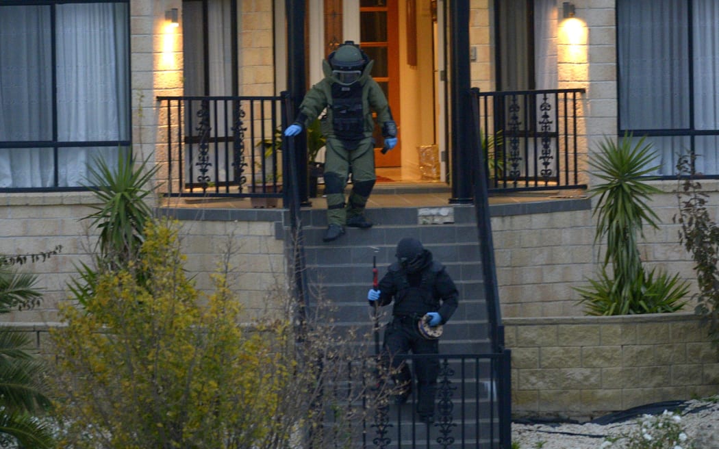 Officers wearing bomb suits raid a home in Greenvale, Melbourne, on Friday 8 May.