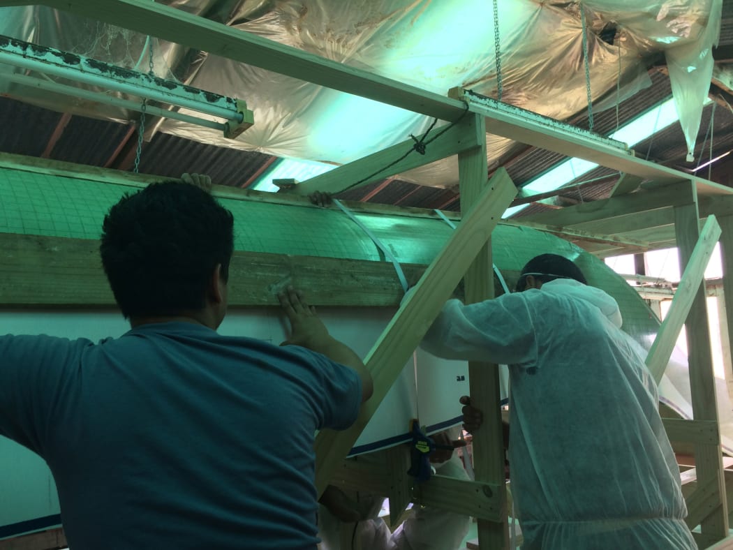 The team works on the canoe.