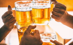 Friends toasting with glasses of light beer at the pub.