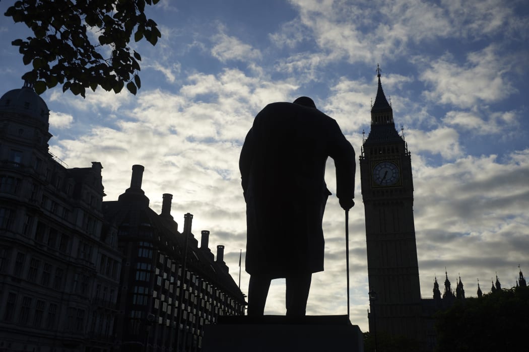 A statue of Winston Churchill is silhouetted by Big Ben and the Houses of Parliament in central London on the morning the Brexit results were announced.