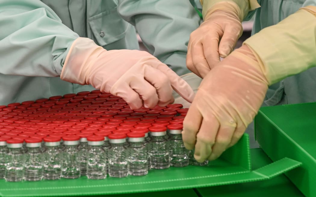 Laboratory technicians handle vials as part of tests for the production and supply of the University of Oxford Covid-19 vaccine candidate, AZD1222, at Catalent Biologics, in Italy.
