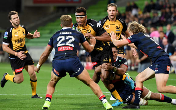 Western Force player Jordan Olowofela (C) takes on the Rebels defence during the Super Rugby Australia match between the Melbourne Rebels and the Western Force in Melbourne on April 9, 2021.