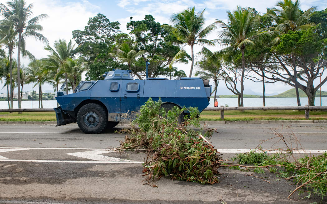 A Gendarmerie armored vehicle drives past the filtering roadblock set up on the bays, Promenade Pierre Vernier, in Noumea on May 15, 2024, amid protests linked to a debate on a constitutional bill aimed at enlarging the electorate for upcoming elections of the overseas French territory of New Caledonia. One person was killed, hundreds more were injured, shops were looted and public buildings torched during a second night of rioting in New Caledonia, authorities said May 15, as anger over constitutional reforms from Paris boiled over. (Photo by Delphine Mayeur / AFP)