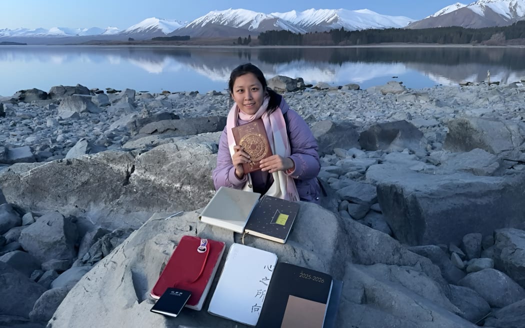 Chinese tourists gather at Lake Tekapo, adding their words to a growing collection.