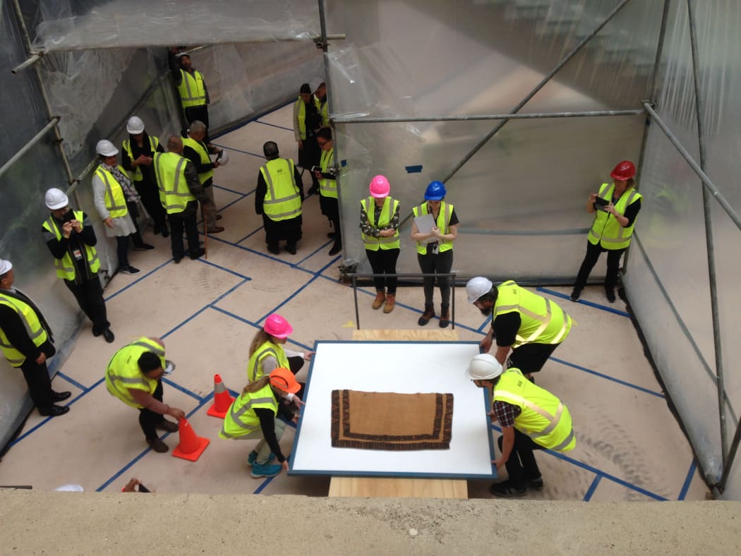 Auckland Museum staff carefully moving fragile kakahu (cloaks) to their new basement home through a purpose built tunnel to prevent damage from dust during recent construction work.