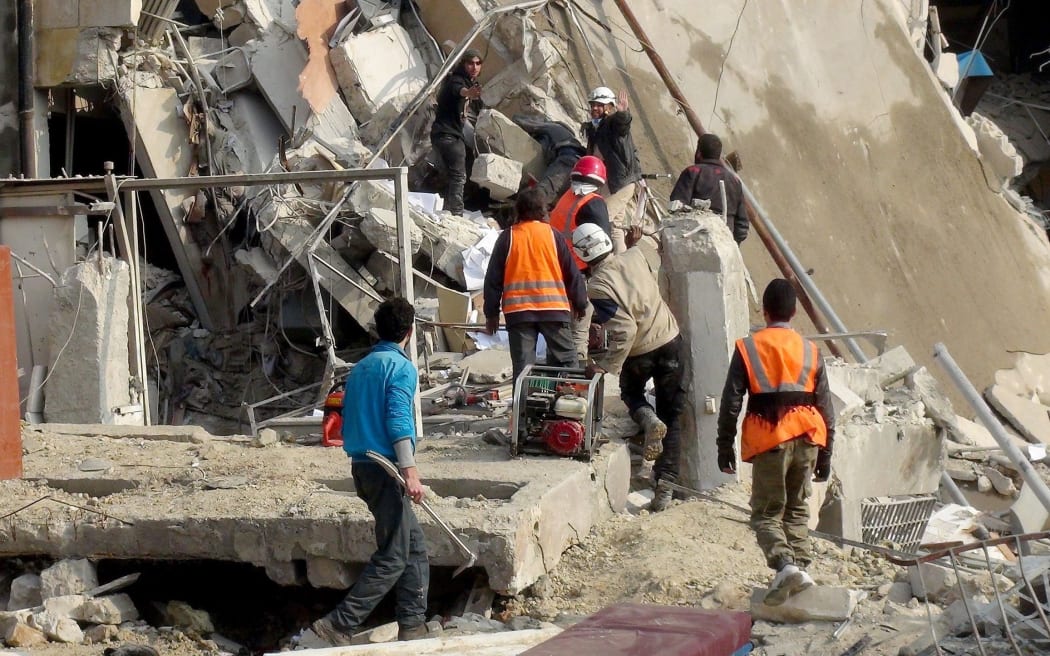 Civil defence team members try to search casualties among Idlib's destroyed buildings after the Russian army carried out airstrikes on the opposition-controlled residential areas in Idlib, Syria on December 20, 2015. Abdurrahman Sayed / Anadolu Agency