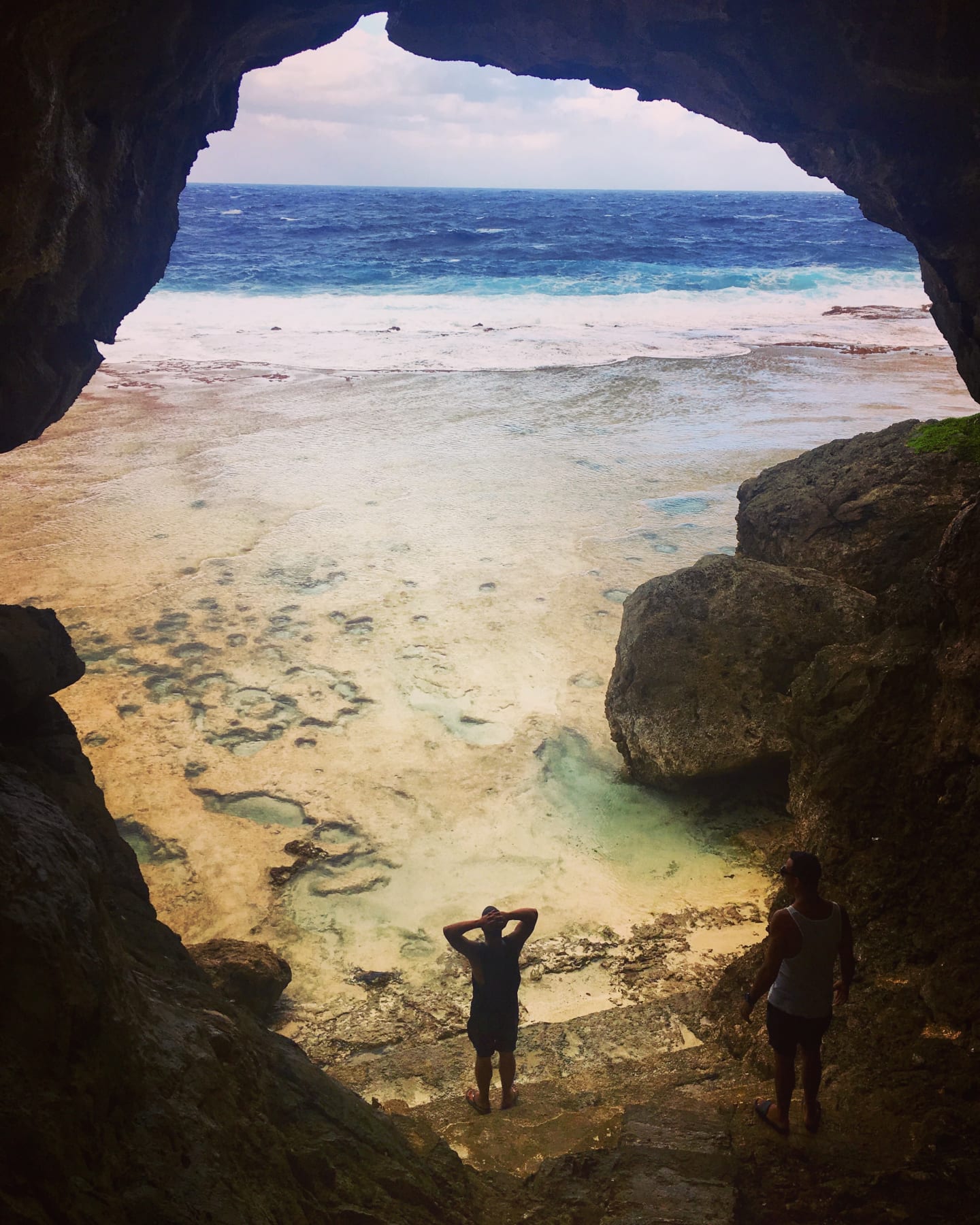 Presenter, Shimpal Lelisi, framed by the caves of Niue, looks out to the ocean