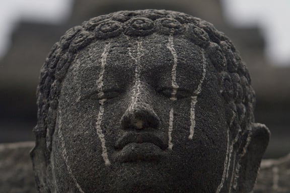 Volcanic ash smears a stone figure of Buddha at the Borobudur temple in central Java.