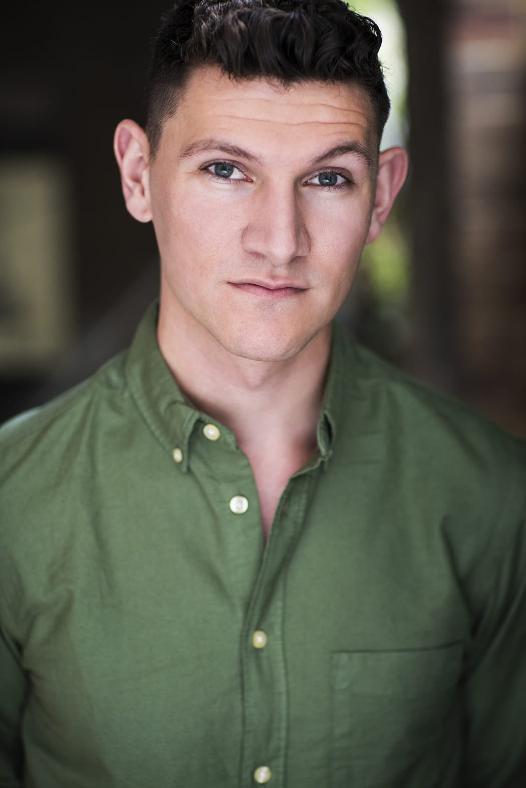 A professional headshot of Steven Kramer. Steven gazes at the camera. He wears a green button-down shirt.