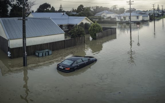 A partly-submerged car outside flooded houses on Disraeli St, Westport.