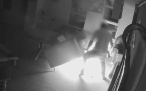 CCTV footage shows a resident of Loafers Lodge attempting to put out a fire that was started under a couch in the boarding hostel.