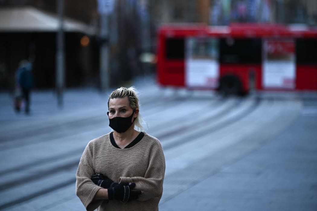 SYDNEY, AUSTRALIA - JUNE 26: A woman wearing mask walks at partially empty Sydney Central Business District during the first day of lockdown in Sydney, Australia, Saturday, June 26, 2021.