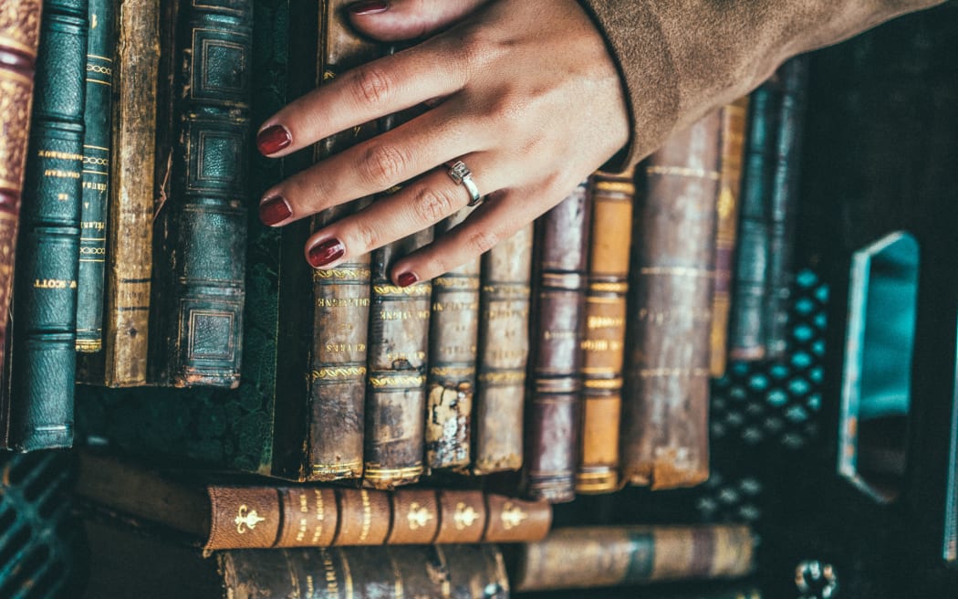 Hand lies on old books