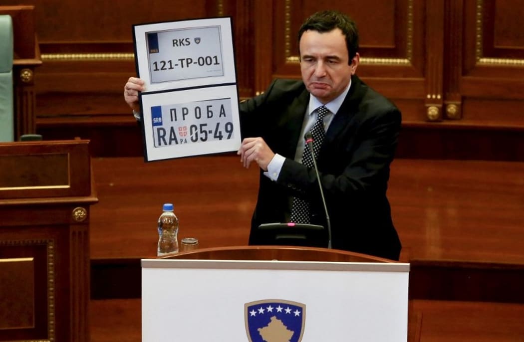 Kosovo Prime Minister Albin Kurti shows Kosovo and Serbia temporary car plates during a parliament session in Pristina on September 20, 2021.