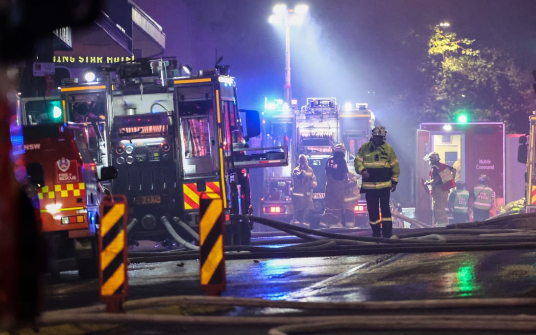 Firemen work at the scene of a fire at a building in Sydney on May 25, 2023. More than 100 firefighters battled towering flames and thick smoke from a seven-storey blaze in central Sydney on May 25, warning that it is spreading to other buildings. (Photo by DAVID GRAY / AFP)