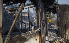 Firefighters battle the Tick Fire in houses on fire in Brentwood, California.