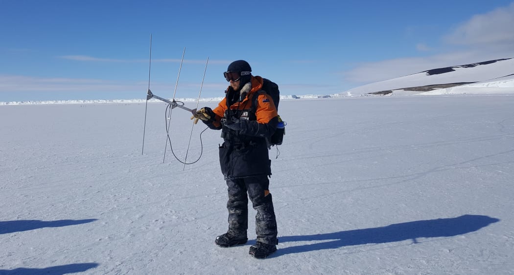 Researcher Parker Forman scans for tagged Emperor penguins returning from the sea to the colony at Cape Crozier, in Antarctica.