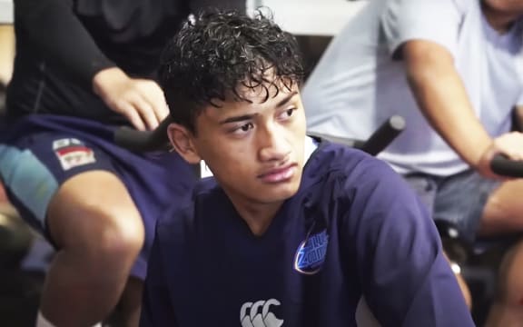 A boy in a blue rugby shirt looking off-camera
