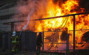 Members of emergency services respond to a fire after a Russian attack targeted energy infrastructure in Kyiv, Ukraine on October 18, 2022.