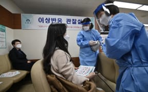 Medical staff check a nursing home worker after receiving the first dose of the AstraZeneca vaccine.